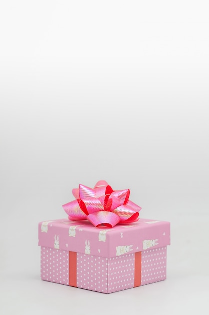 Caja de regalo rosa con cinta rosa sobre un fondo blanco Felicitaciones en varias ocasiones - fotos