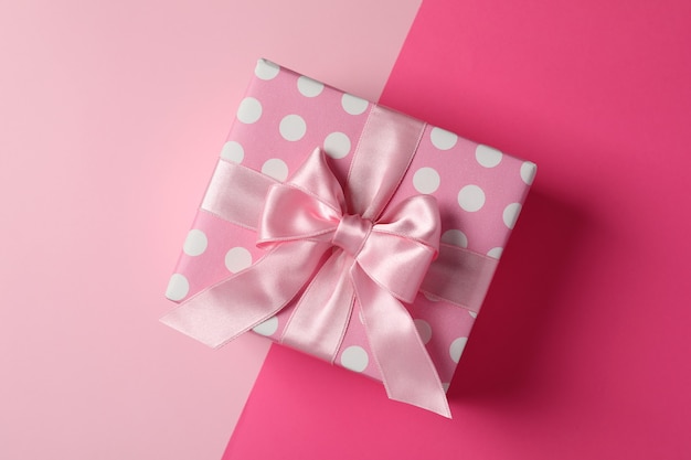 Caja de regalo rosa sobre fondo de dos tonos