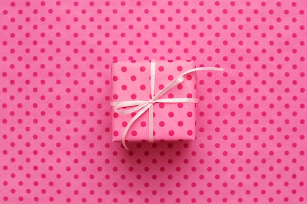 Caja de regalo rosa sobre fondo rosa con lunares