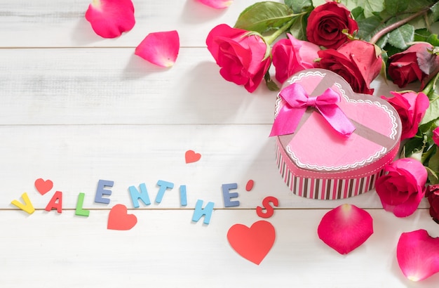 Foto caja de regalo rosa y el texto de san valentín con rosa roja sobre fondo blanco de madera, amor y san valentín '