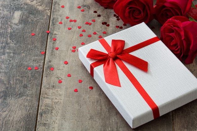 Caja de regalo y rosas rojas en concepto de madera de San Valentín