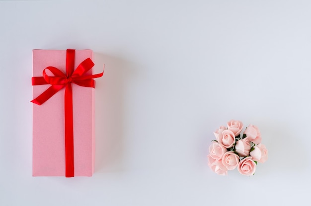 Caja de regalo con rosas sobre fondo blanco.