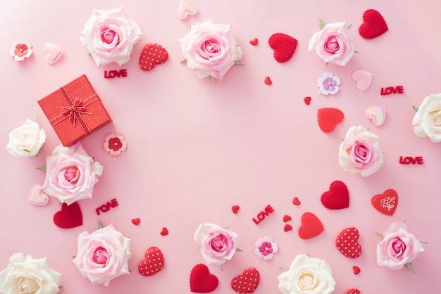 Caja de regalo de San Valentín con corazones rojos y rosas sobre fondo rosa