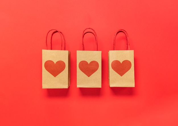 Caja de regalo de San Valentín y corazones sobre fondo rojo.