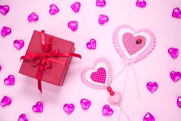 Caja de regalo sobre fondo rosa. Dos rosas en forma de corazón. Regalo para niña.