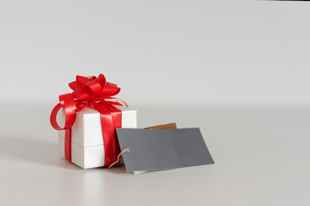 Caja de regalo con tarjeta de felicitación en blanco sobre la mesa. Concepto de San Valentín o cumpleaños.
