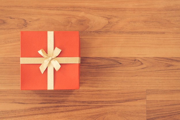 Foto caja de regalo de vacaciones de navidad y año nuevo envuelto con papel rojo y lazo de cinta amarilla
