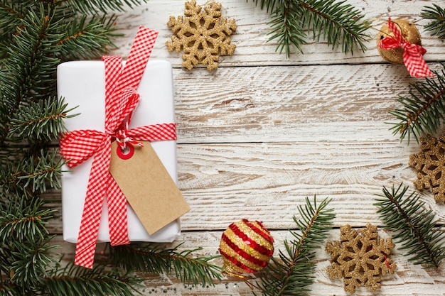 Caja de regalo de vacaciones. Regalo de Navidad con etiqueta en el fondo blanco de madera.