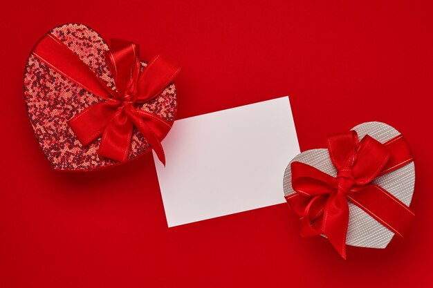 Caja de regalo de varias opciones en forma de corazón con una cinta roja sobre una mesa roja. Concepto de día de San Valentín Vista superior plana con espacio de copia.