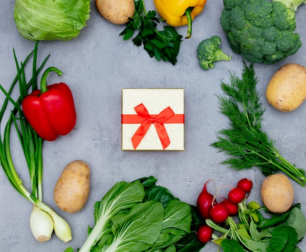 Caja de regalo y verduras sobre una mesa.