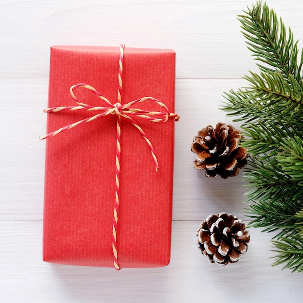 Caja de regalo vintage rojo y adorno sobre fondo de madera blanco, tarjeta de felicitación de Navidad