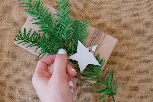Foto caja con regalos de año nuevo envueltos en papel artesanal y decorados con ramas de abeto concepto de vacaciones y regalos hecho a mano alternativa ecológica verde regalos de navidad cero desperdicio