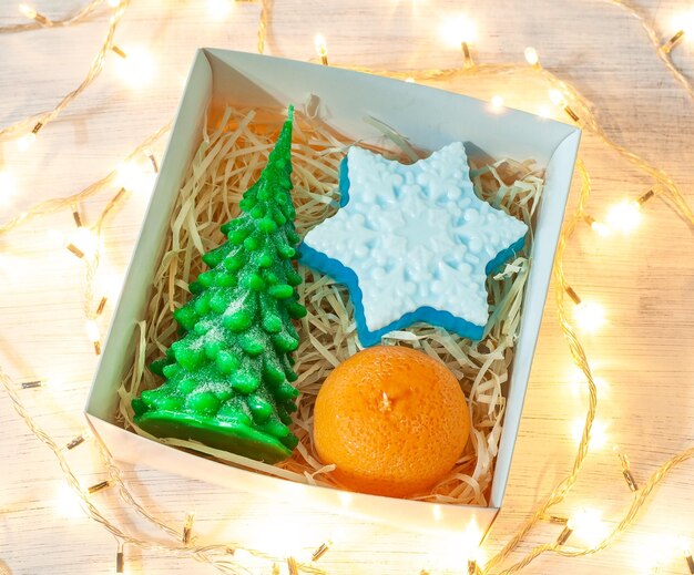 Foto caja de regalos de navidad sobre fondo de madera con guirnalda