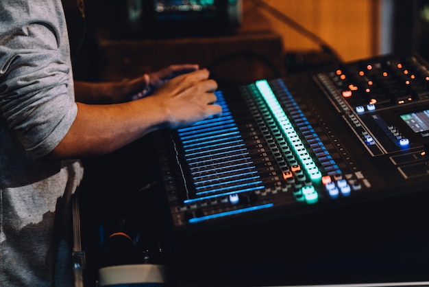 Caja de resonancia profesional que incluye panel de control de mezclador de audio con botones y controles deslizantes.