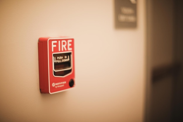 Una caja roja de alarma contra incendios en una pared con un cartel que dice fuego.