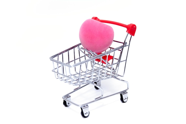 Foto caja rosa para un anillo en forma de corazón en un carrito de compras sobre fondo blanco concepto de vacaciones día de san valentín compras