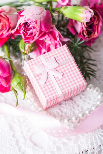 Caja rosa con regalito y flores.