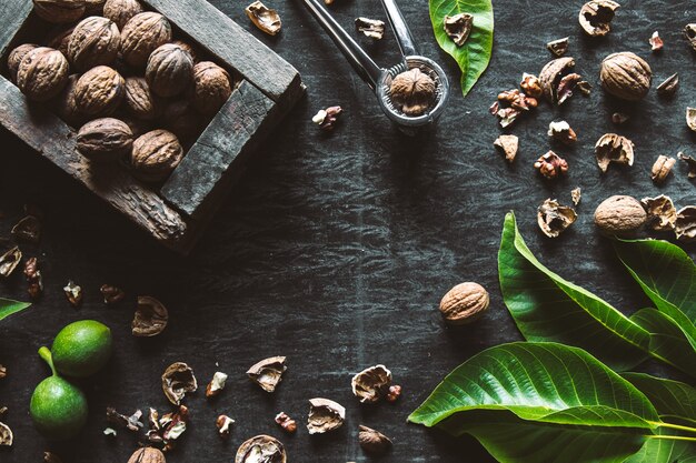 Caja con sabrosas nueces y cascanueces en la mesa de madera oscura, primer plano