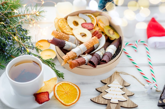 Caja de té y regalo con chips de fruta seca en mesa de madera