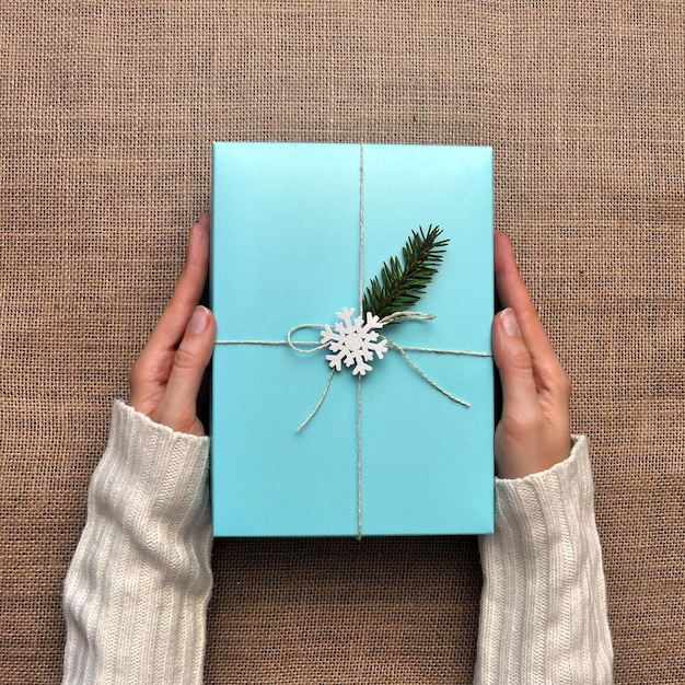 Caja de vacaciones azul en manos de una mujer.