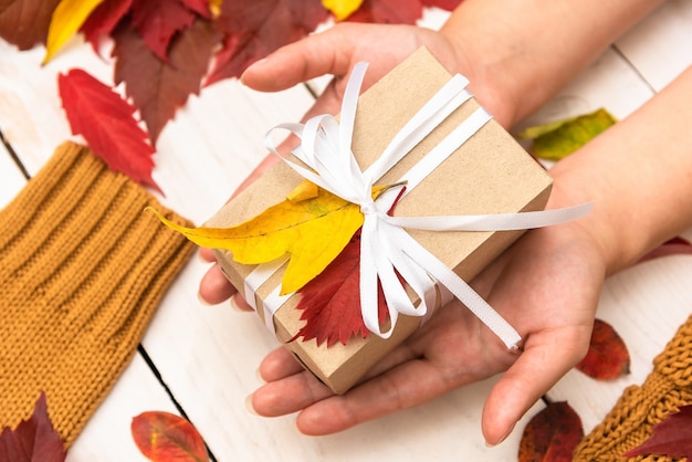 Caja de vacaciones de otoño en la mano.