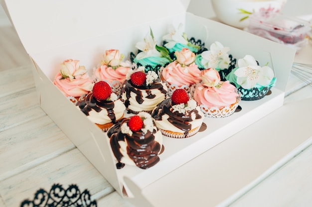 Una caja con una variedad de deliciosos cupcakes en un backgrou de madera