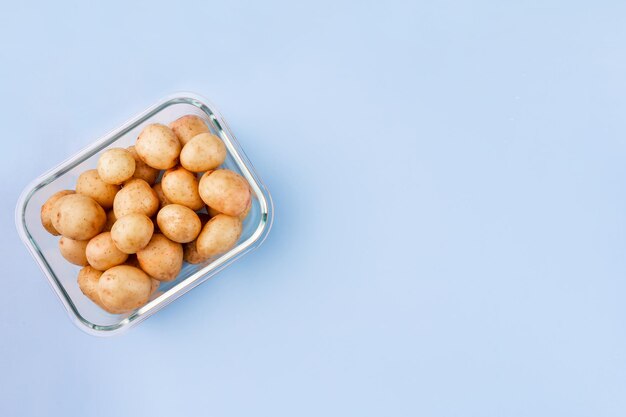 Caja de vidrio con papas crudas frescas Verduras en recipientes de vidrio Concepto de almacenamiento de alimentos