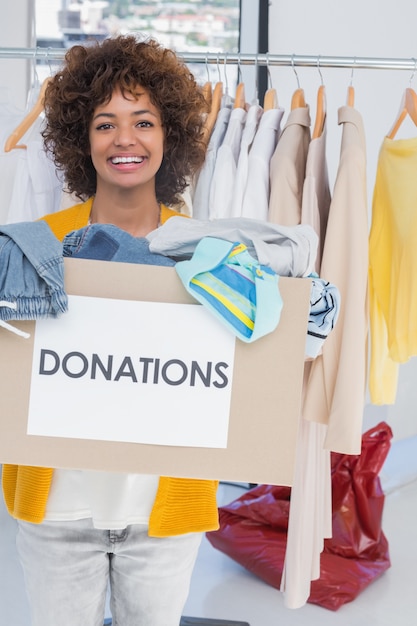 Foto caja voluntaria de la donación de la ropa de la tenencia joven