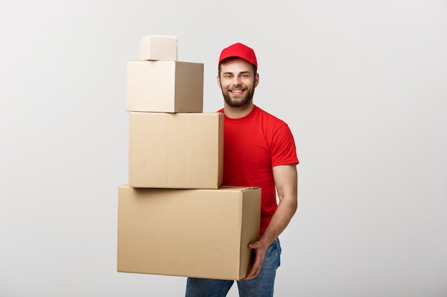 Cajas de cartón hermosas de la pila del control del hombre de entrega en fondo gris.