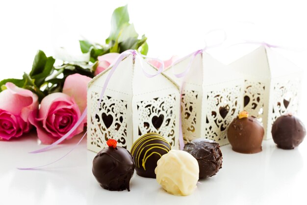 Cajas decorativas cuadradas de encaje blanco con forma de corazón rellenas de trufas gourmet.