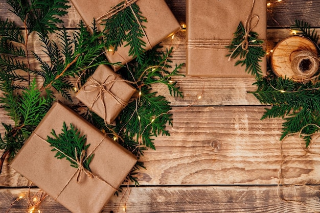 Cajas empaquetadas con papel kraft y cordel natural sobre un fondo de madera.Material ecológico.Navidad y Año Nuevo.