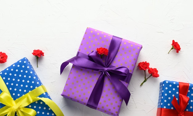 Las cajas están empaquetadas en papel navideño con lunares y atadas con una cinta de seda sobre un fondo, regalo de cumpleaños, sorpresa.