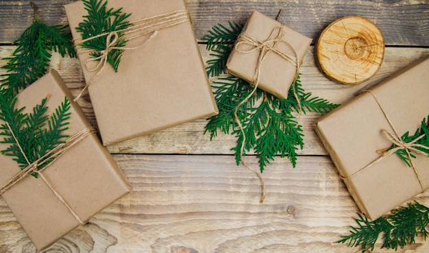 Cajas llenas de papel kraft y cordel natural sobre un fondo de madera. El concepto de Navidad y Año Nuevo.