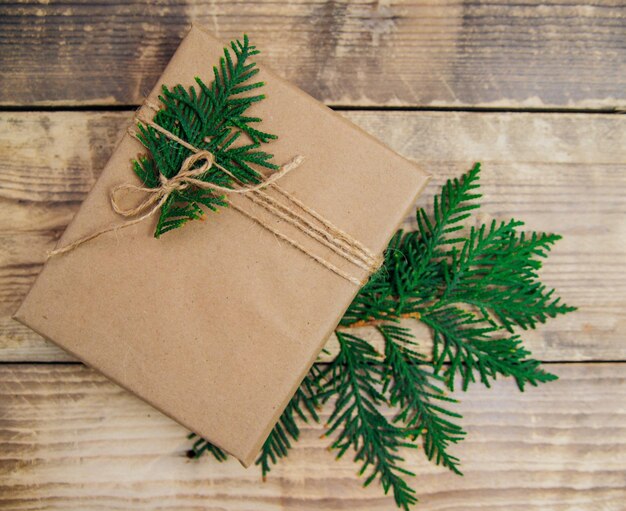 Foto cajas llenas de papel kraft y hilo natural sobre un fondo de madera navidad y año nuevo
