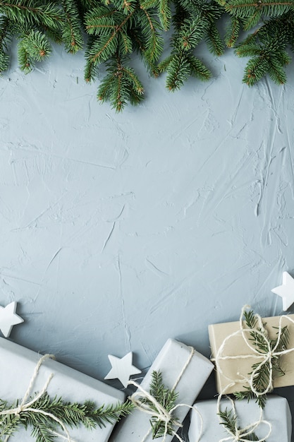 Cajas de Navidad y ramas sobre fondo gris