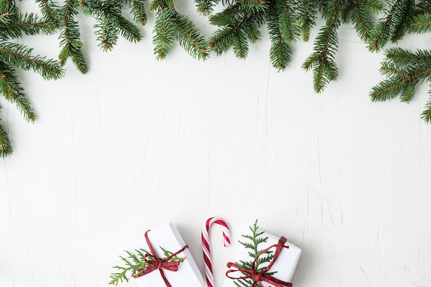 Cajas de Navidad y ramas sobre fondo gris