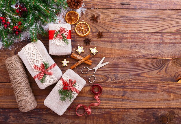 Cajas navideñas artesanales y rama con nieve.