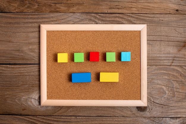 Cajas rectangulares de cubo de muestra pulidas con varios colores que simbolizan el desarrollo del crecimiento de la estabilidad alineadas en la superficie con diferentes perspectivas delimitadas por accesorios de suministros electrónicos