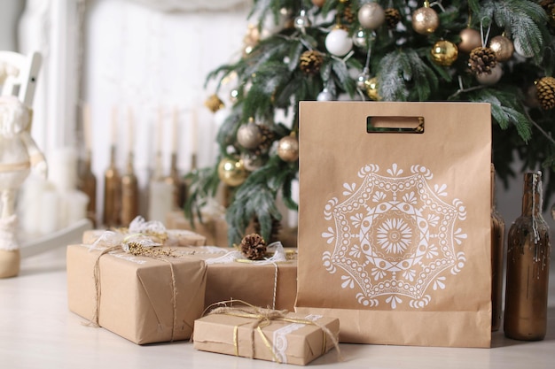 Cajas de regalo de adornos navideños en papel de regalo cerca del árbol de navidad