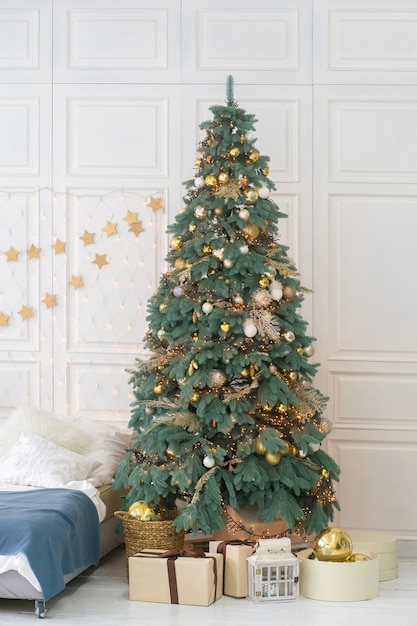 Cajas de regalo bajo el árbol de Navidad sobre un piso de madera blanca