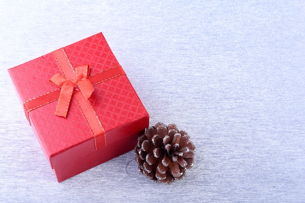 Cajas de regalo con arco y bolas de navidad sobre fondo de madera