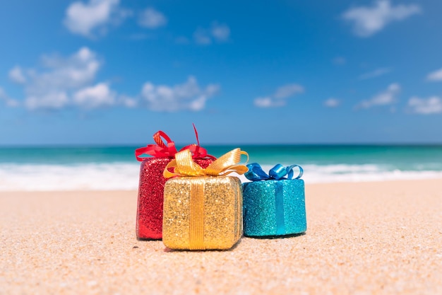 Foto cajas de regalo en la arena con fondo de playa de verano