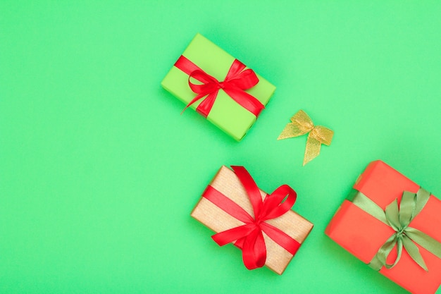 Cajas de regalo atadas con cintas sobre fondo verde. Concepto de tarjeta de felicitación. Vista superior con espacio de copia.