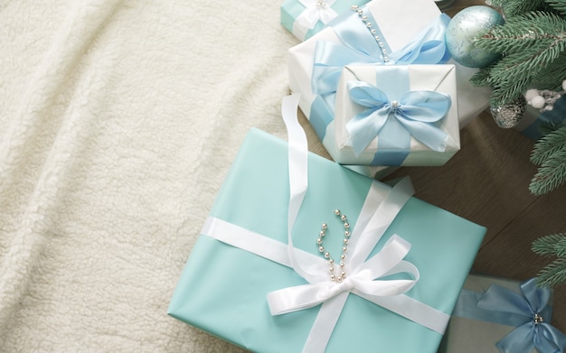 Cajas de regalo azul y blanco bajo el árbol de Navidad