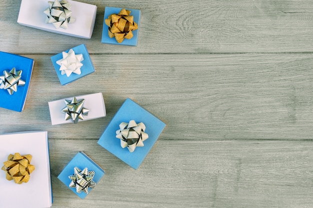 Cajas de regalo blancas y azules decoradas con lazos de oro y plata.