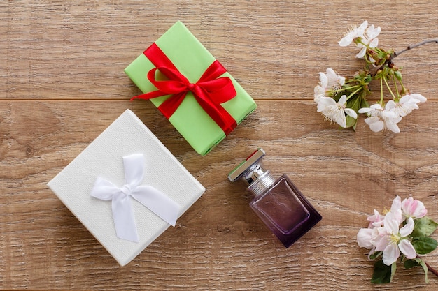 Cajas de regalo una botella de perfume con ramas florecientes de cerezos y manzanos