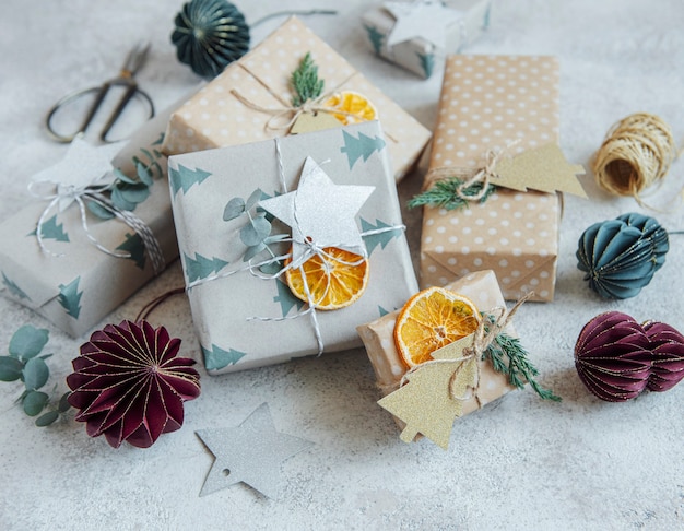 Foto cajas de regalo caseras decorativas navideñas envueltas en papel kraft marrón sobre un fondo de hormigón gris