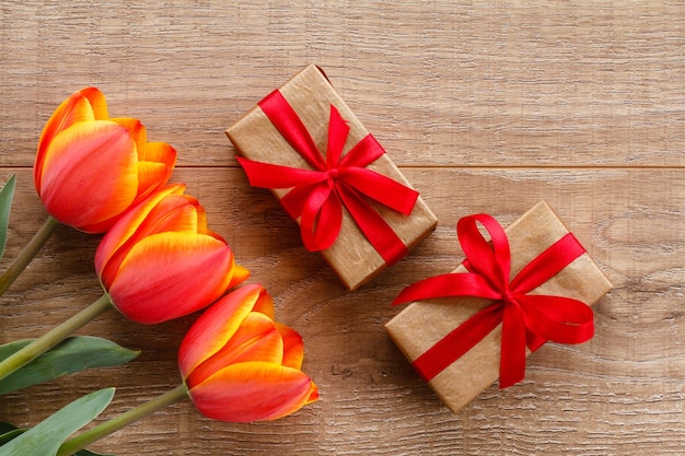 Cajas de regalo con cintas rojas sobre tablas de madera. Concepto de tarjeta de felicitación. Vista superior.