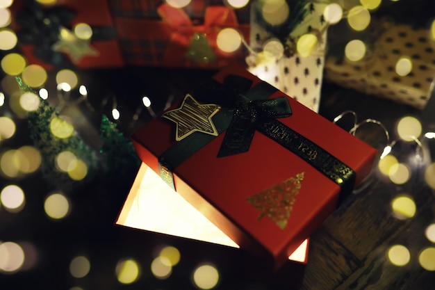 Foto cajas de regalo contra un fondo bokeh de luces de fiesta centelleantes regalo de año nuevo de lujo regalo de navidad fondo de navidad con caja de regalo celebración navideña