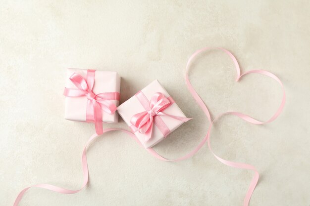 Cajas de regalo y corazón de cinta sobre fondo blanco con textura